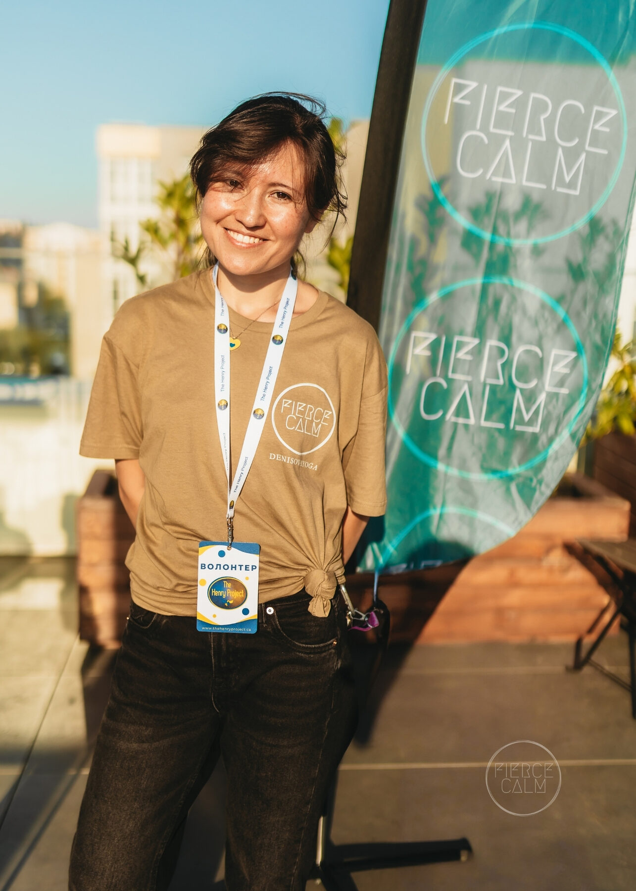 Fierce Calm volunteer smiling beside a branded banner