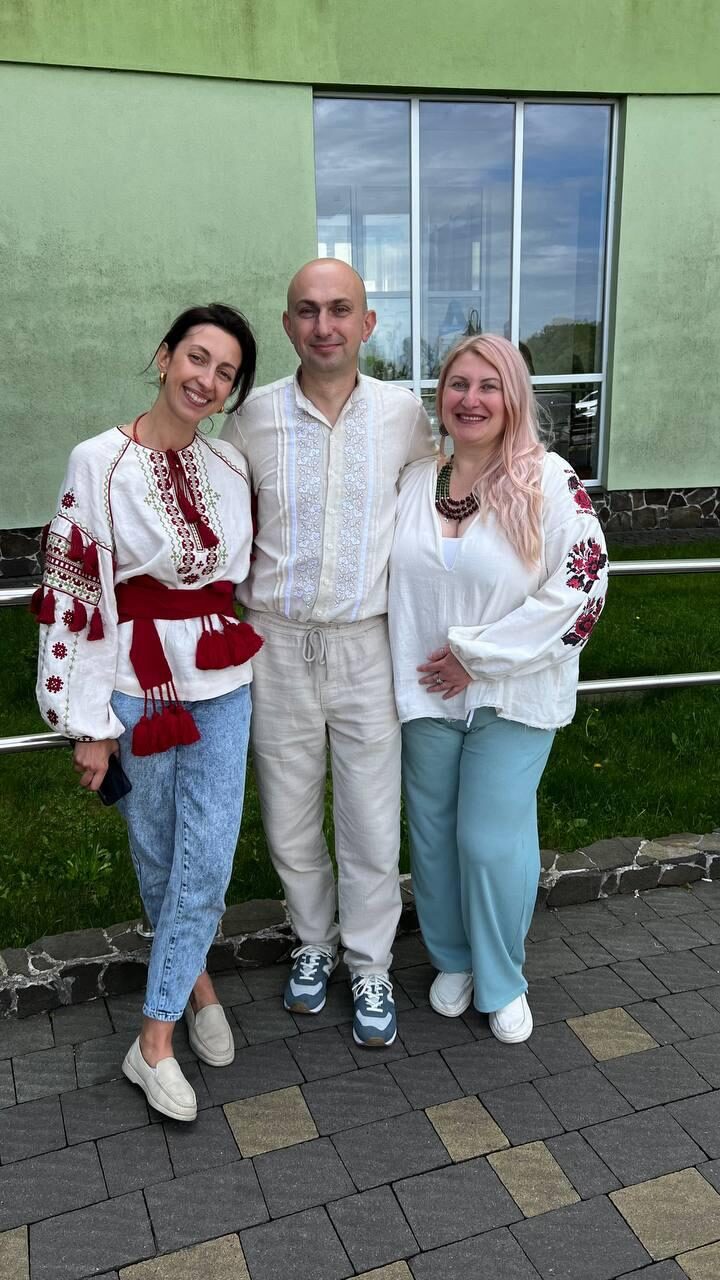 Three community members standing together outdoors