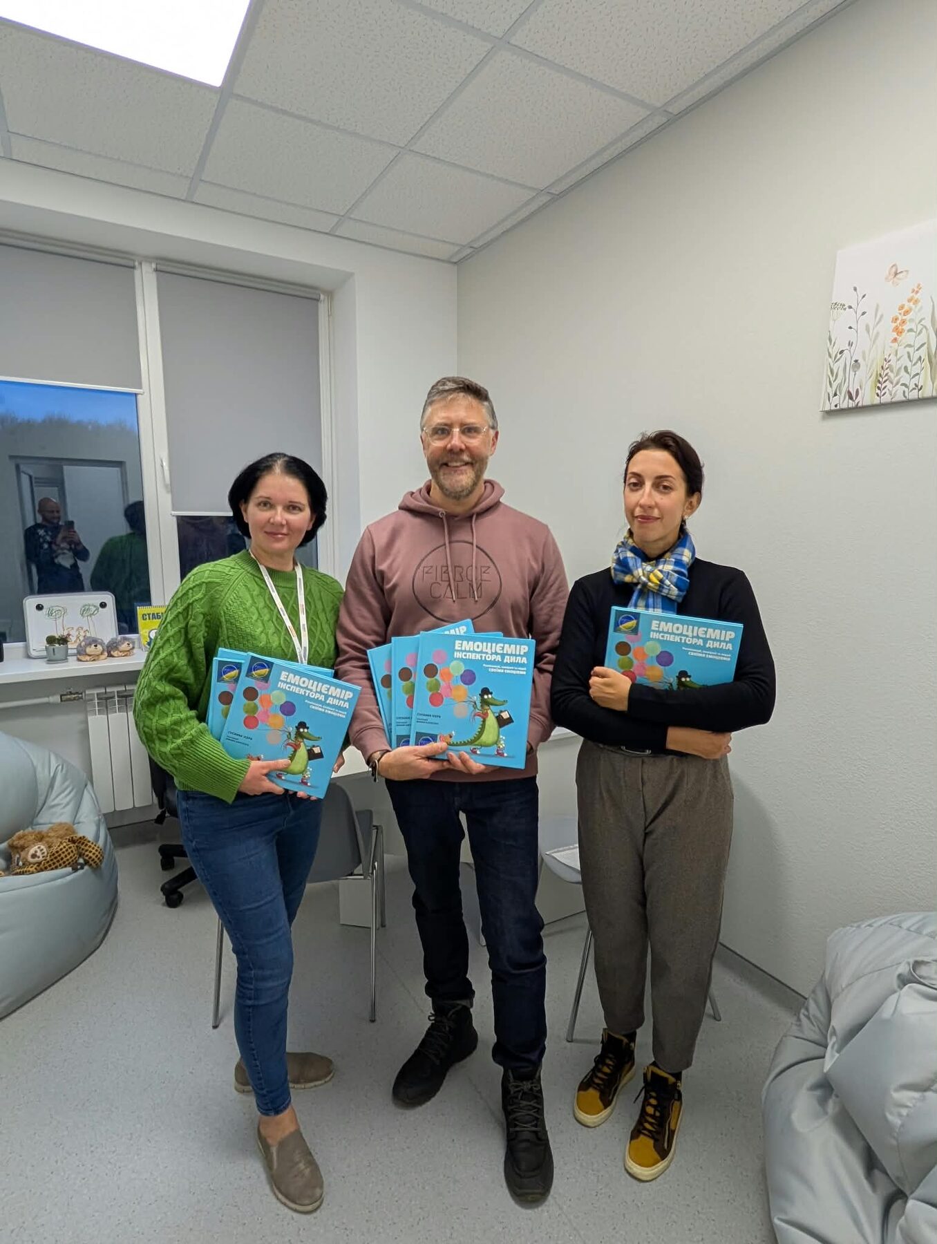 Fierce Calm team members holding children's psychology activity books