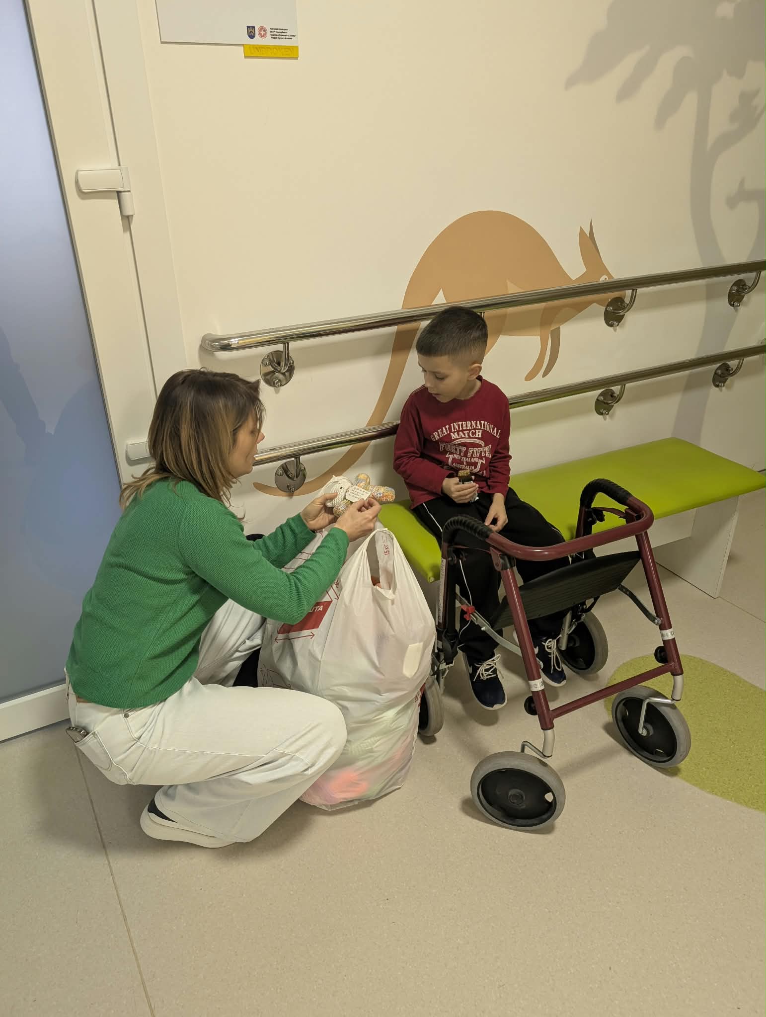 A child receiving a handmade bear in a hospital rehabilitation space