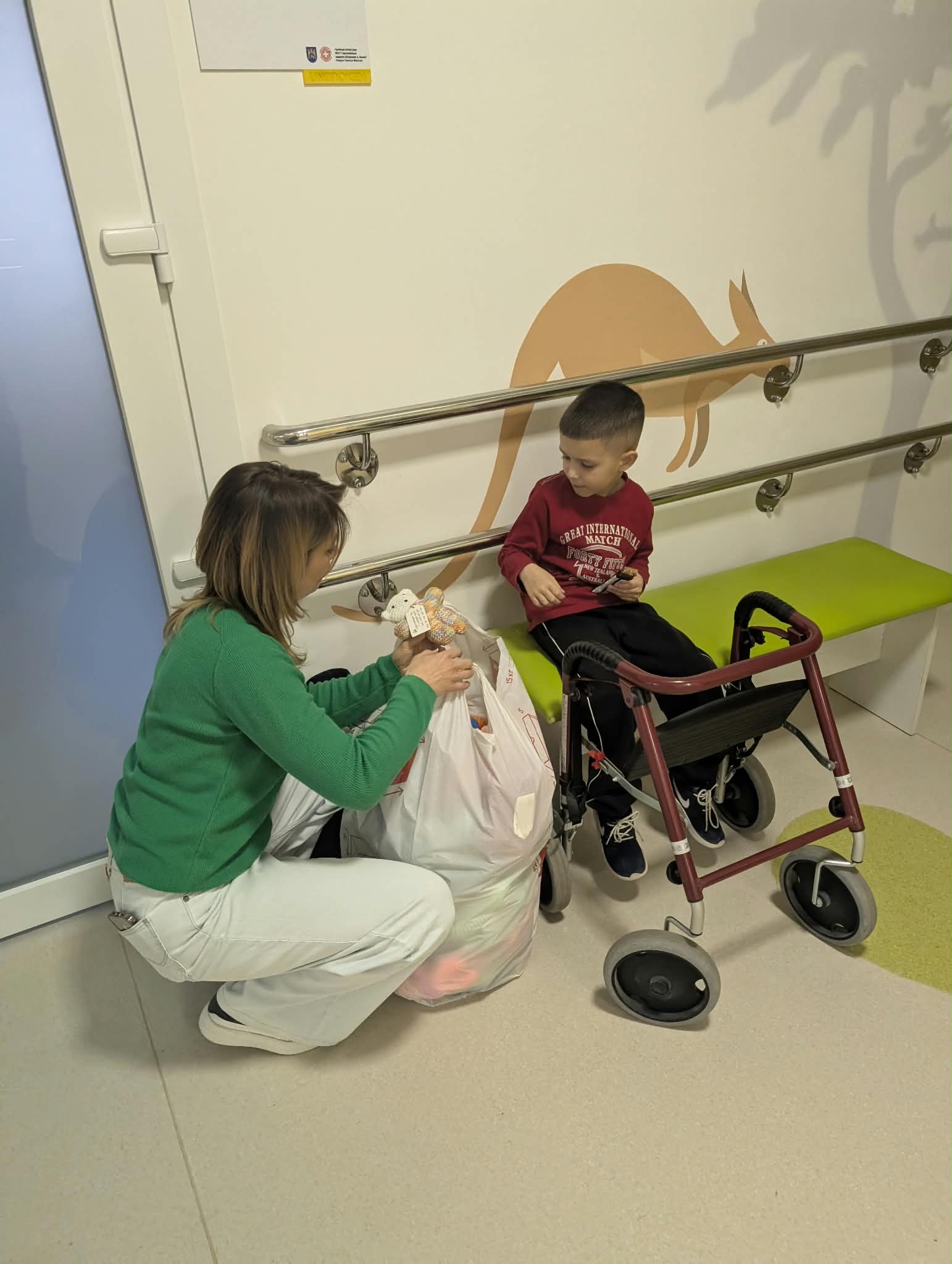 A child receiving a handmade bear in a rehabilitation room