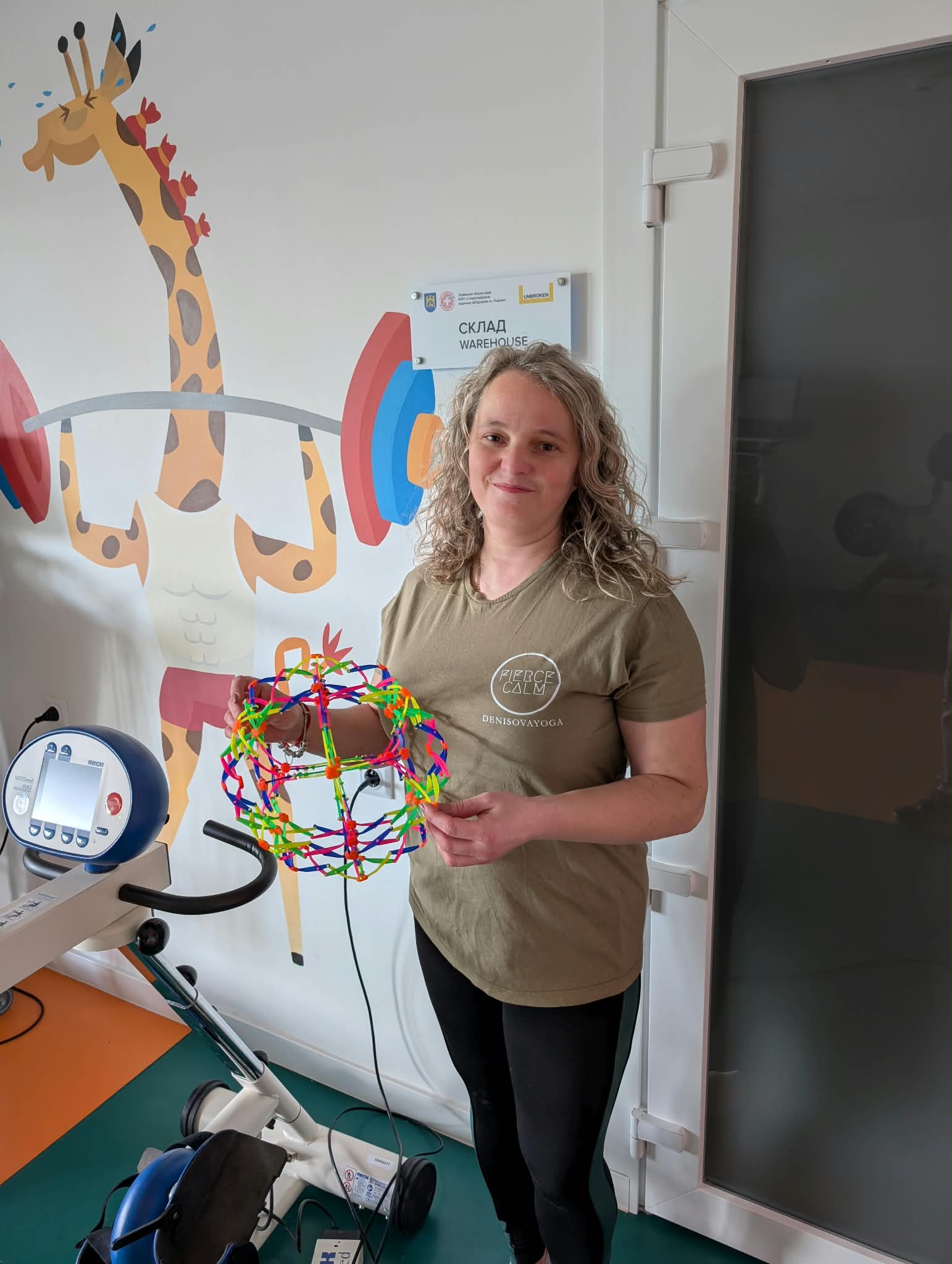 A Fierce Calm practitioner holding a sensory therapy toy in a children's rehabilitation space