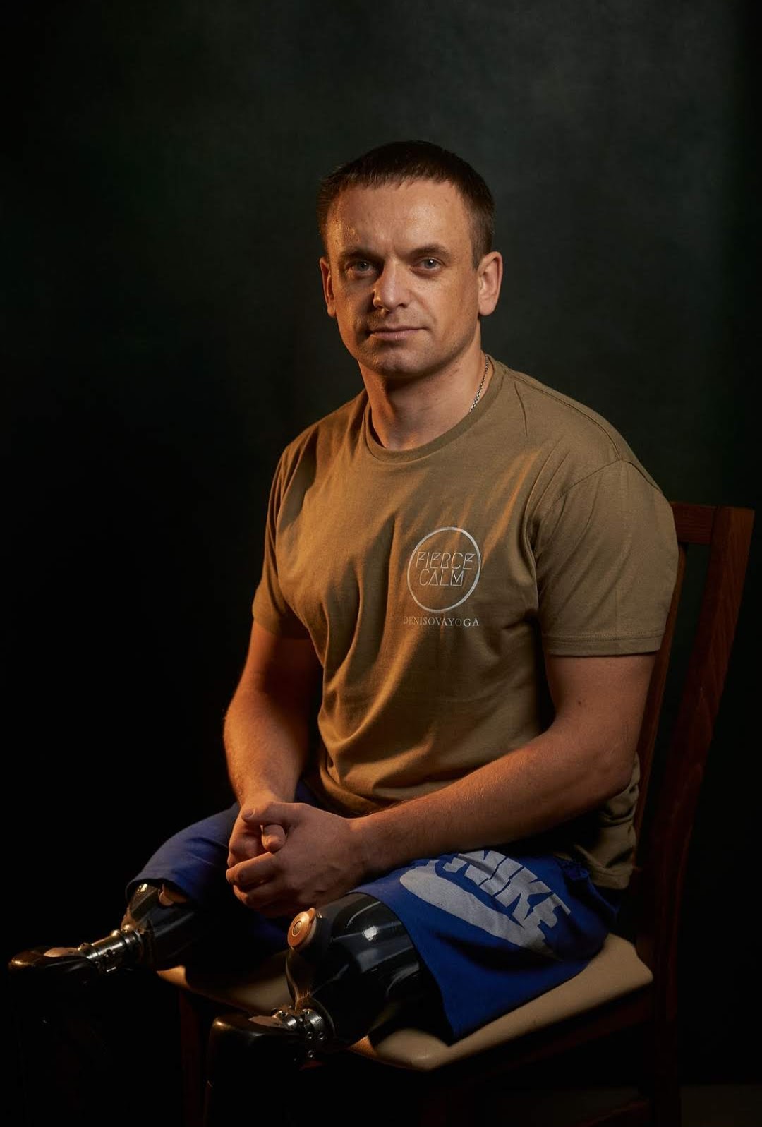 A veteran seated for a portrait with prosthetic legs