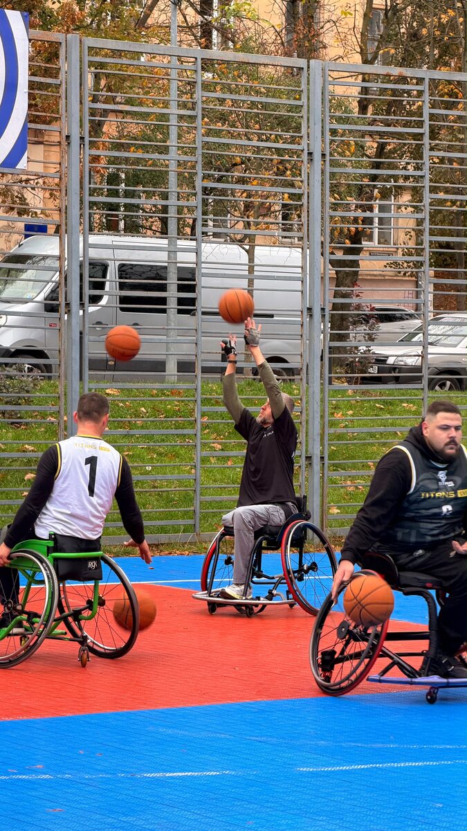 Wheelchair basketball players taking part in a game on an outdoor court